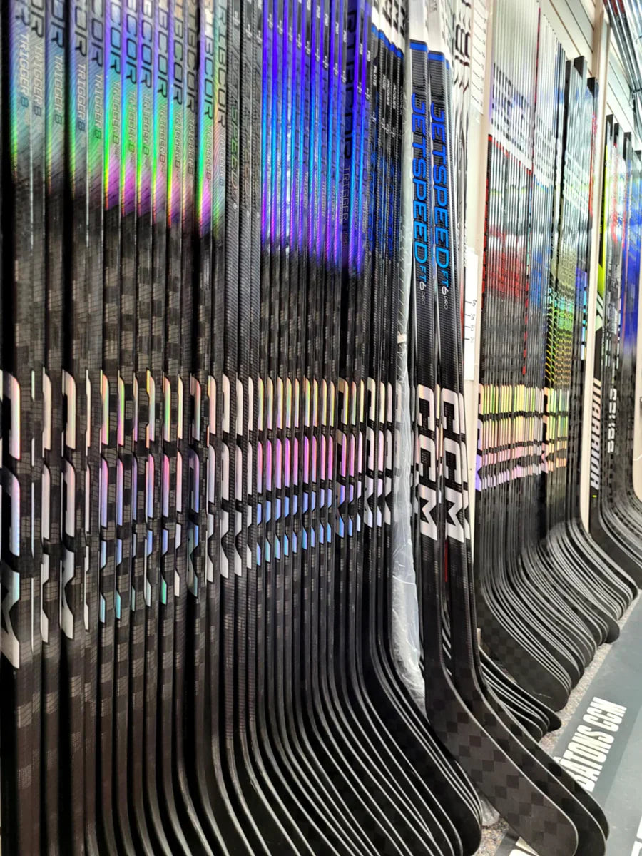 ccm sticks lines up at a hockey store neatly on a rack